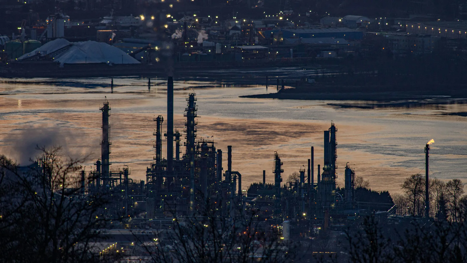 Parkland oil refinery beside a river in Burnaby, British Columbia, at dusk