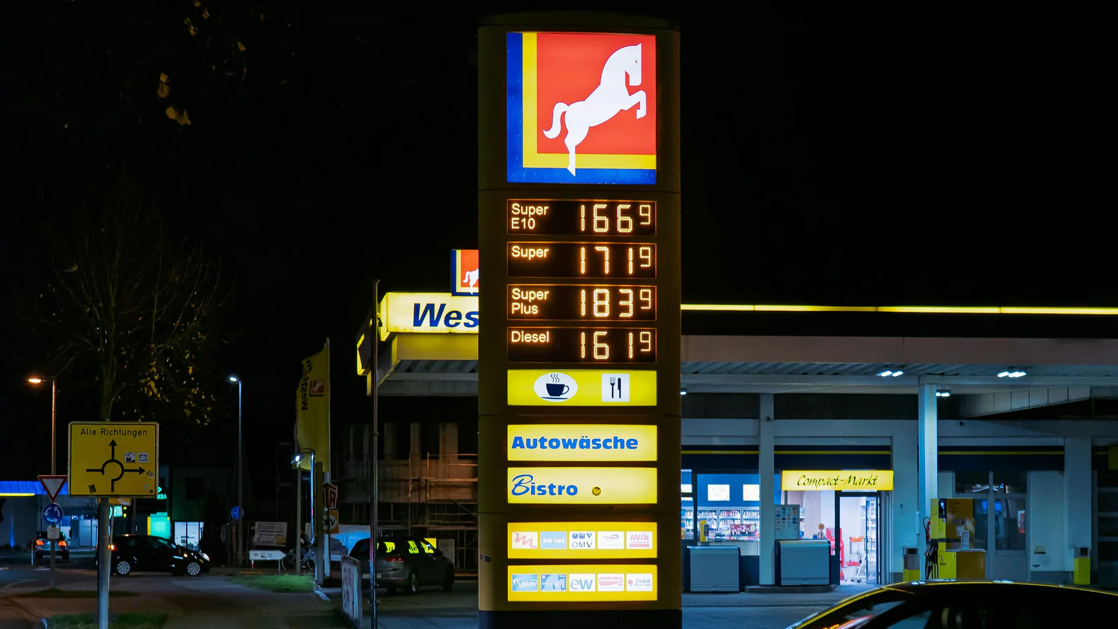 Illuminated German-language fuel price sign at night